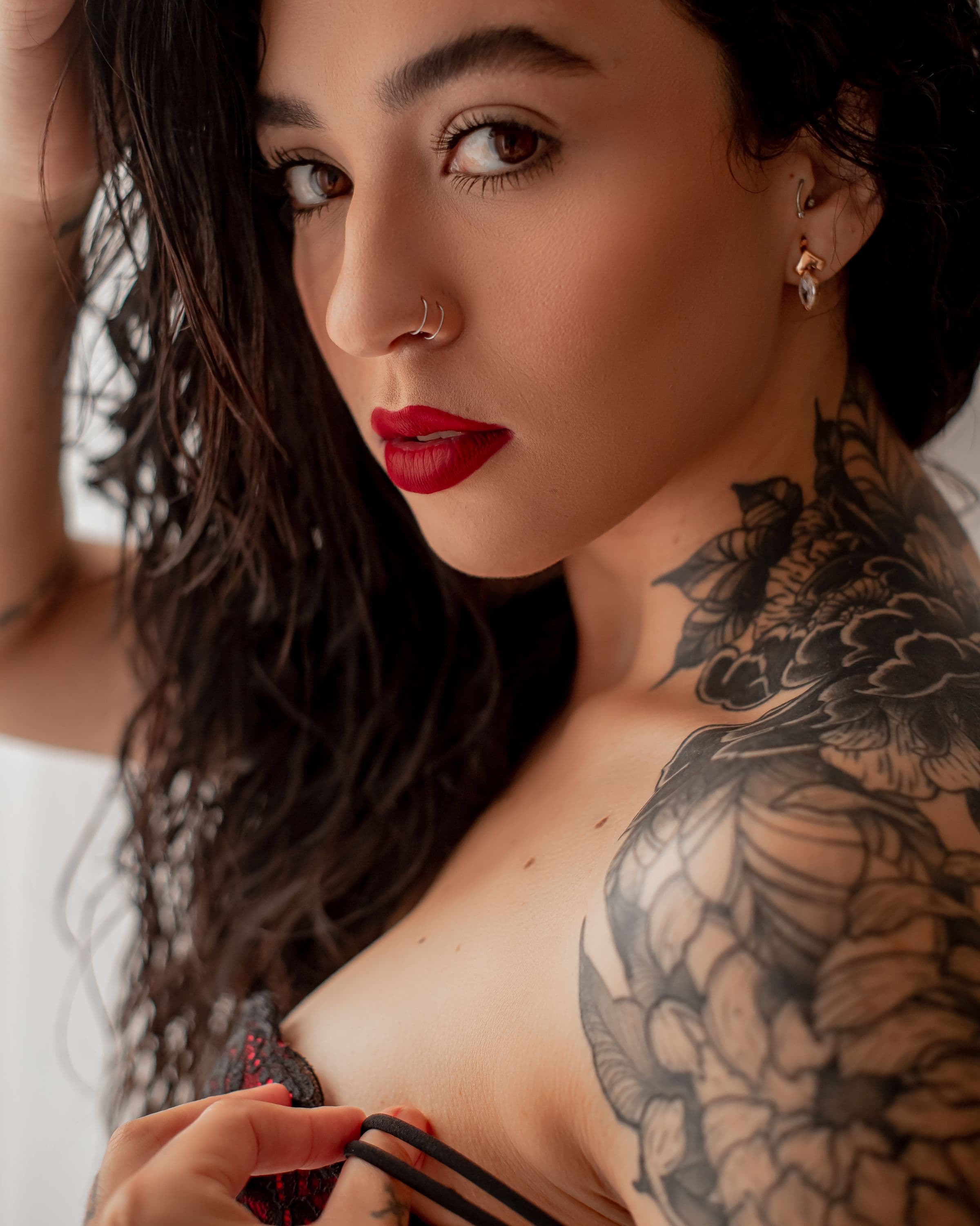 Retrato editorial, olhar direto, tatuagem no ombro, luz de ambiente